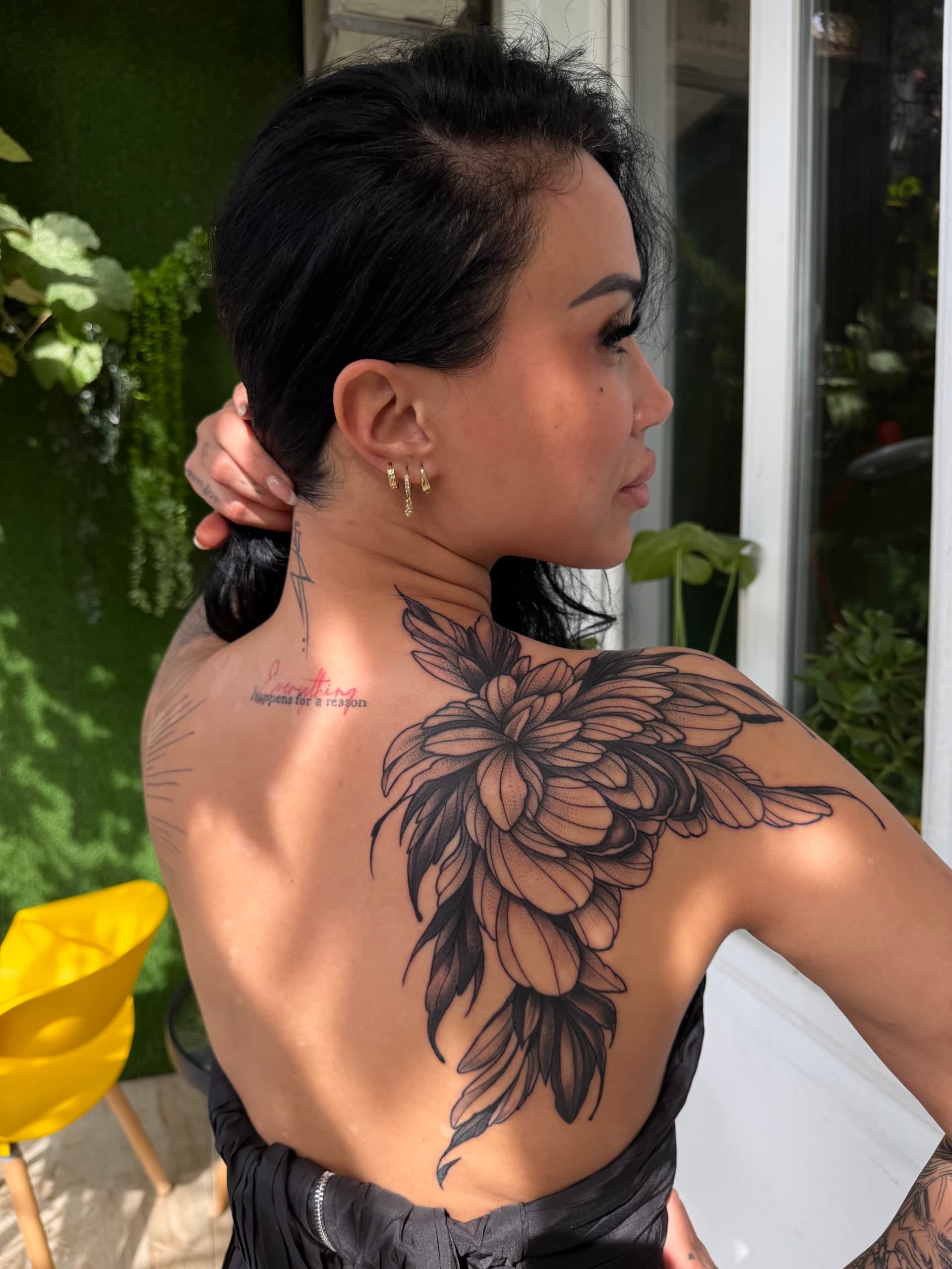 Large floral dotwork tattoo across the shoulder and back